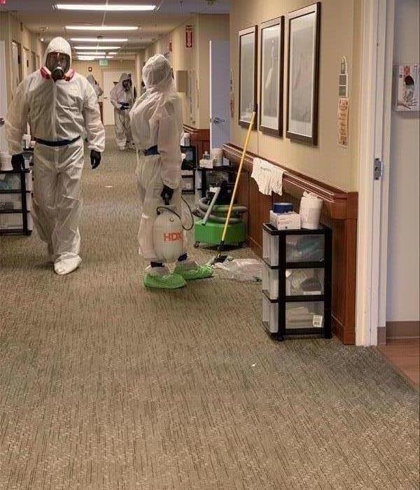 Several SERVPRO employees cleaning a office hallway. 