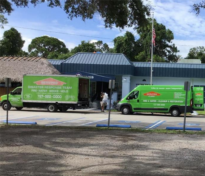 two SERVPRO trucks parked outside of a business